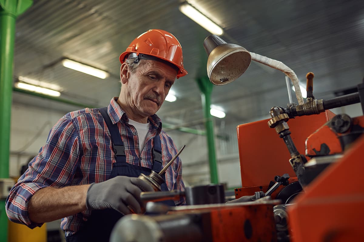 Trabajador manipulando maquinaria industrial con EPI
